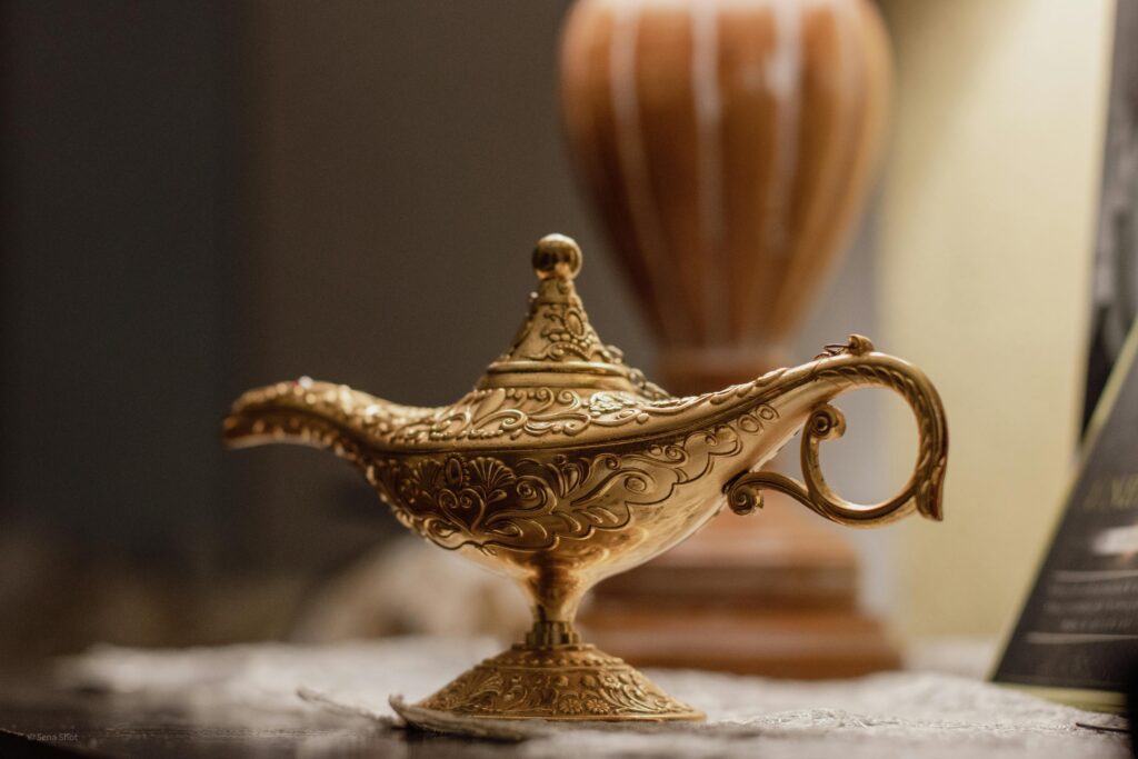 An ornate brass oil lamp sits on a wooden table